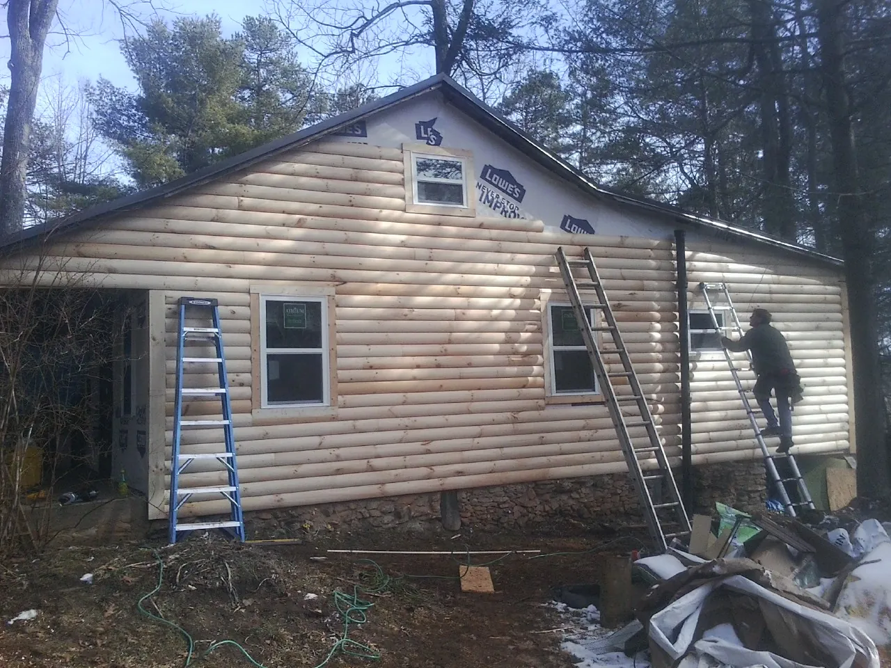 Ladders set against fresh log siding during an exterior remodel in Garner