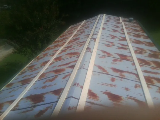 Rusted metal roof panels with new wood purlins before replacement — Storm Damage Roof Repair in Garner by Roofing Brothers