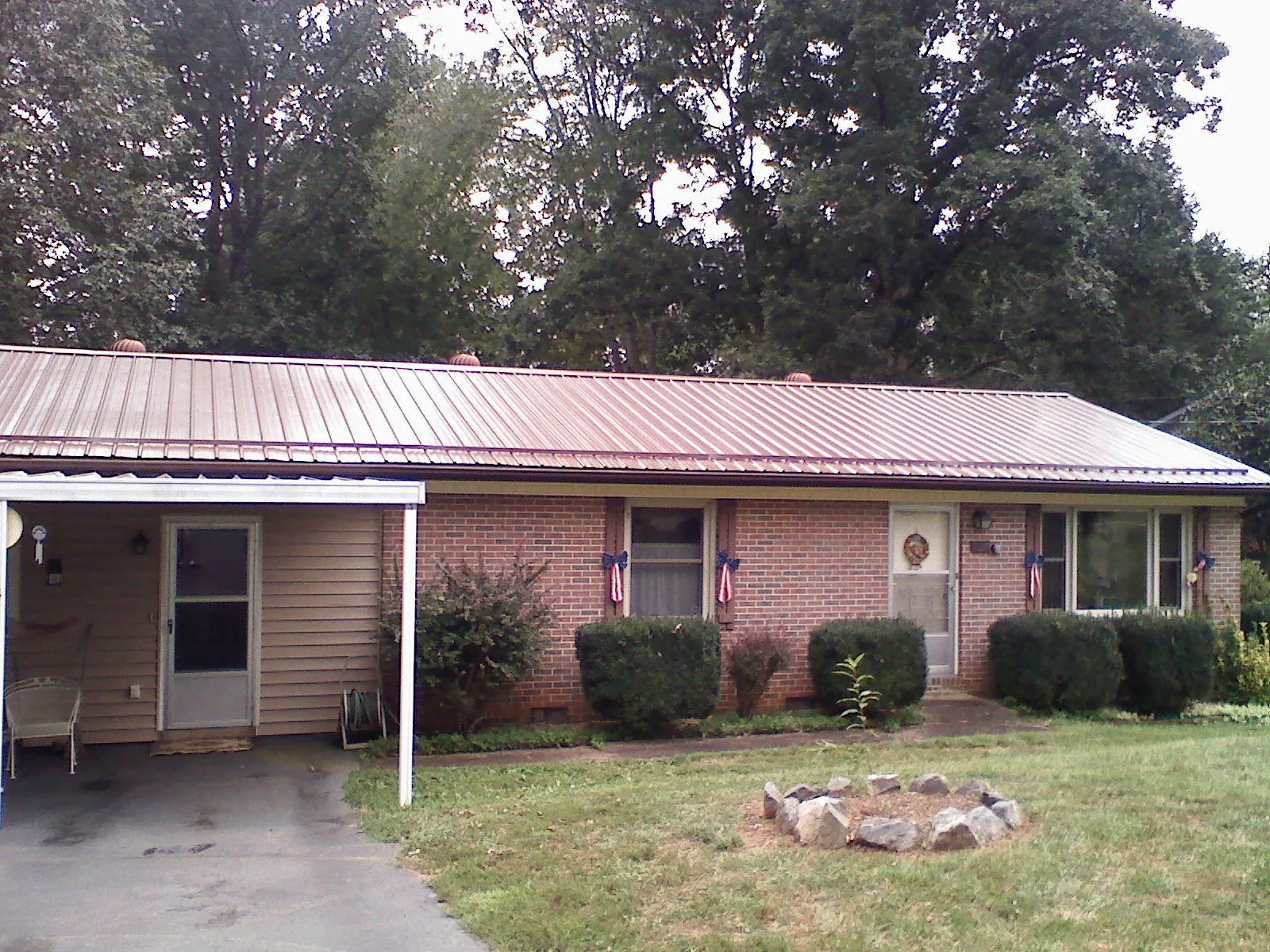 Bronze metal roof and carport on a brick ranch home — Roof Repair work by our crew in Garner