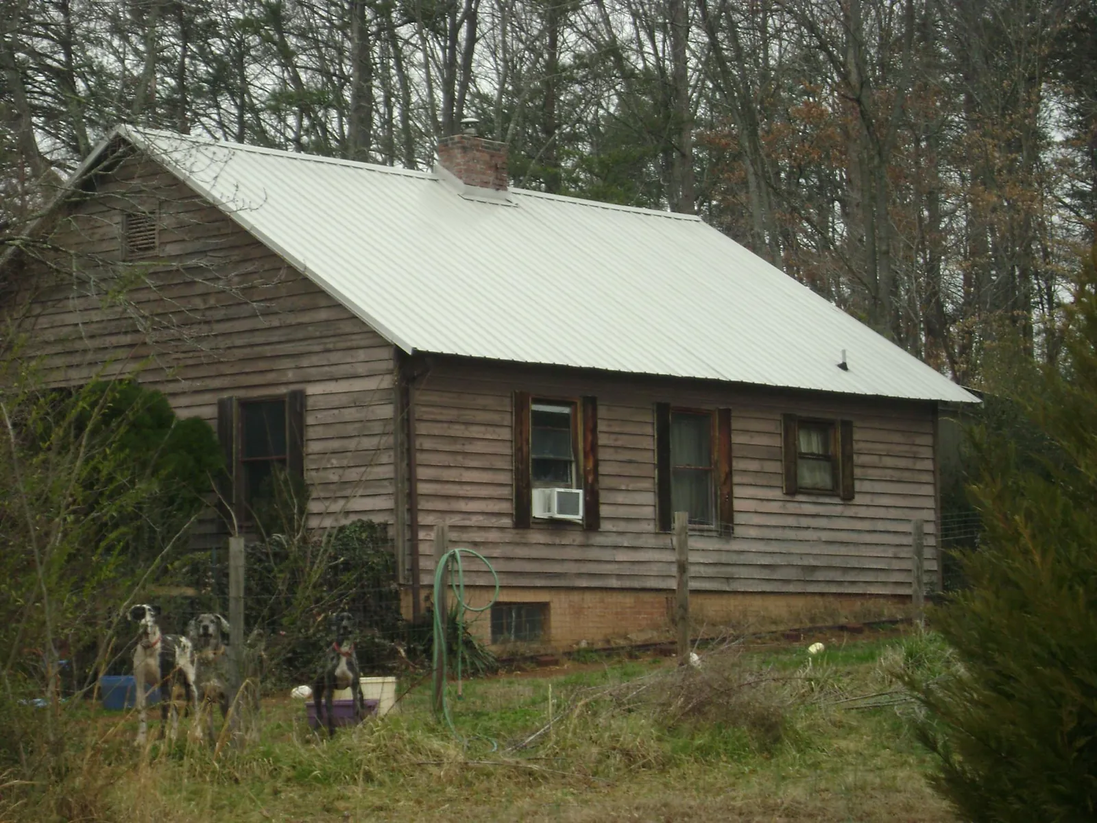 White metal roof on an old wood sided farmhouse, from a Metal Roof Installation job in Garner